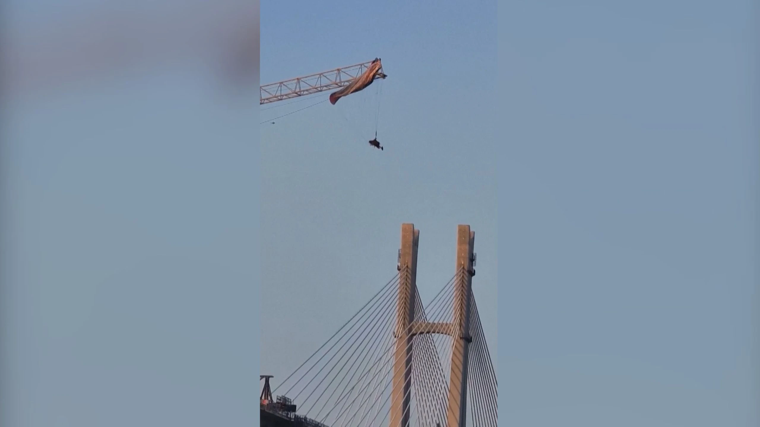 Vídeo: Piloto de parapente fica preso em guindaste na China